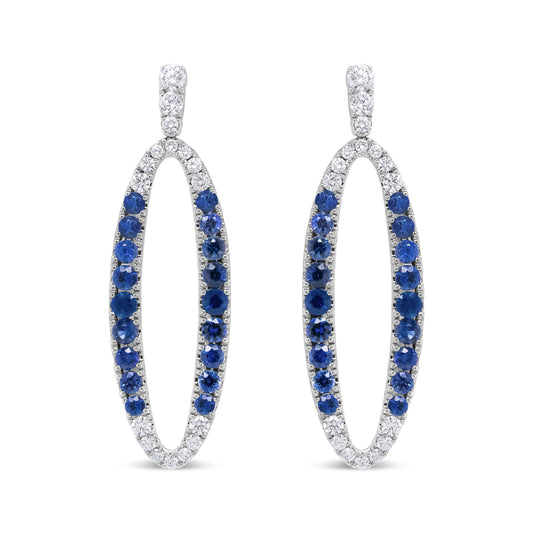 Front view of white metal oval-shaped earrings with alternating white and blue gemstones in prong settings.