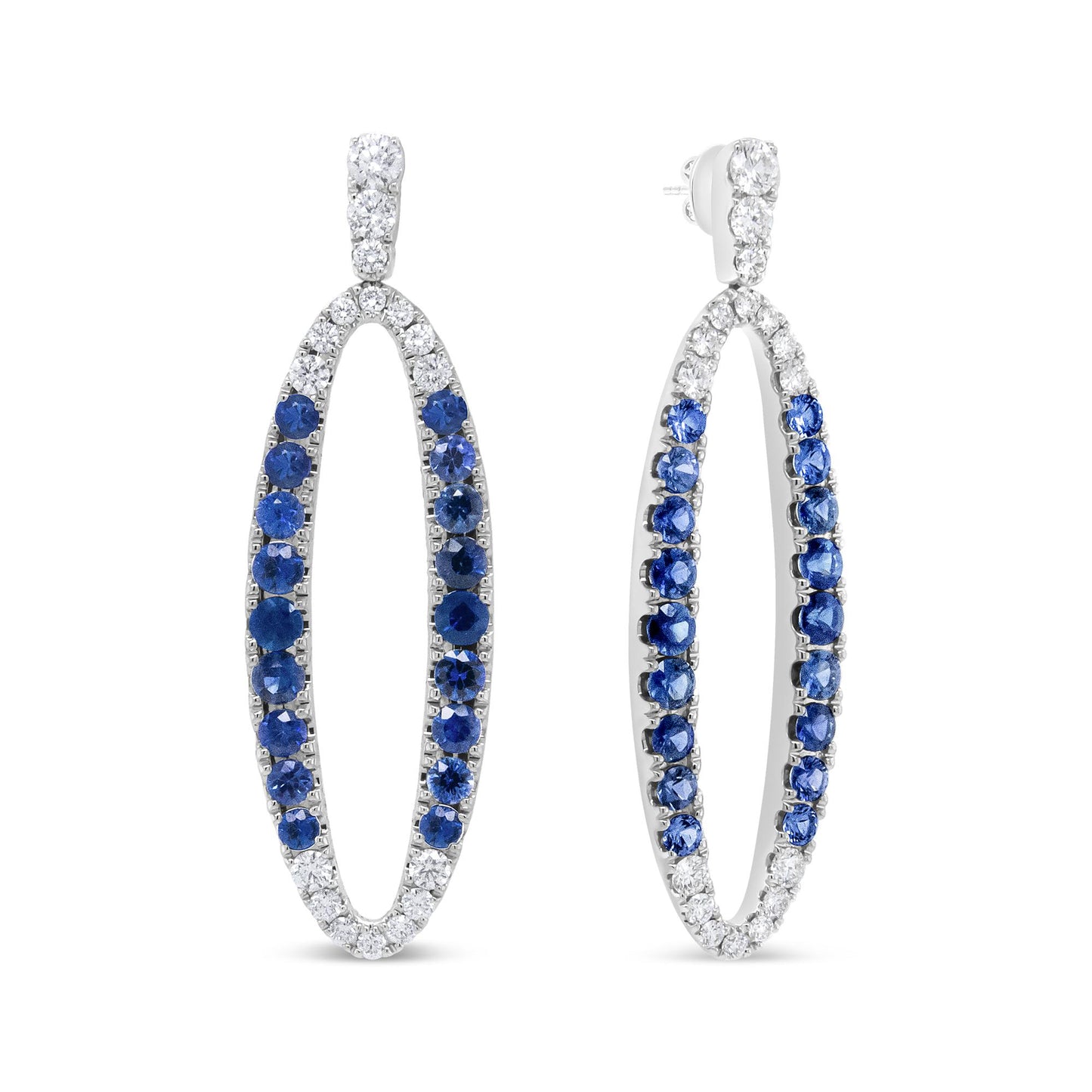 Pair of white metal oval hoop earrings with round prong-set white and blue gemstones, shown from a front and angled side view.