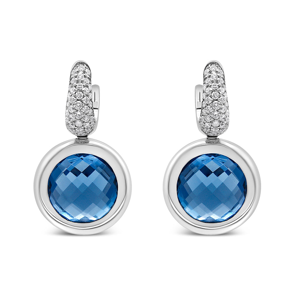 Front view of white metal drop earrings with round blue gemstones set in bezels and tops encrusted with small white gemstones.