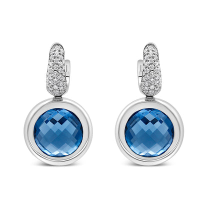 Front view of white metal drop earrings with round blue gemstones set in bezels and tops encrusted with small white gemstones.