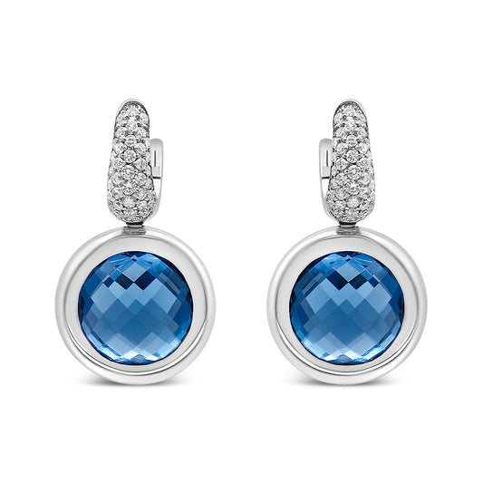 Front view of white metal drop earrings with round blue gemstones set in bezels and tops encrusted with small white gemstones.
