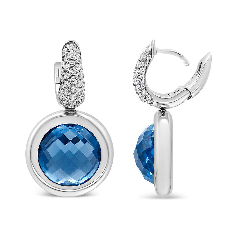 Front and side views of white metal earrings with round blue gemstones in bezel settings surrounded by white gemstones in invisible settings.