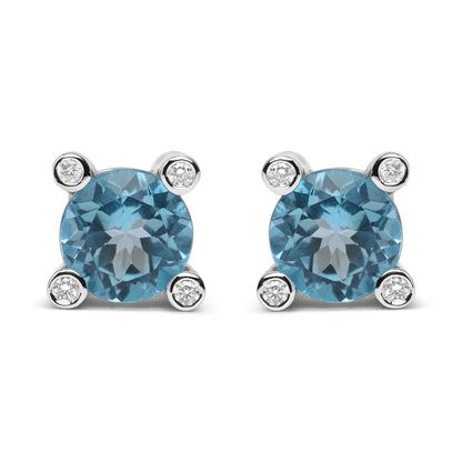 Front view of pair of white metal stud earrings with round blue gemstones prong set in the center and small round white gemstones bezel set at each corner.
