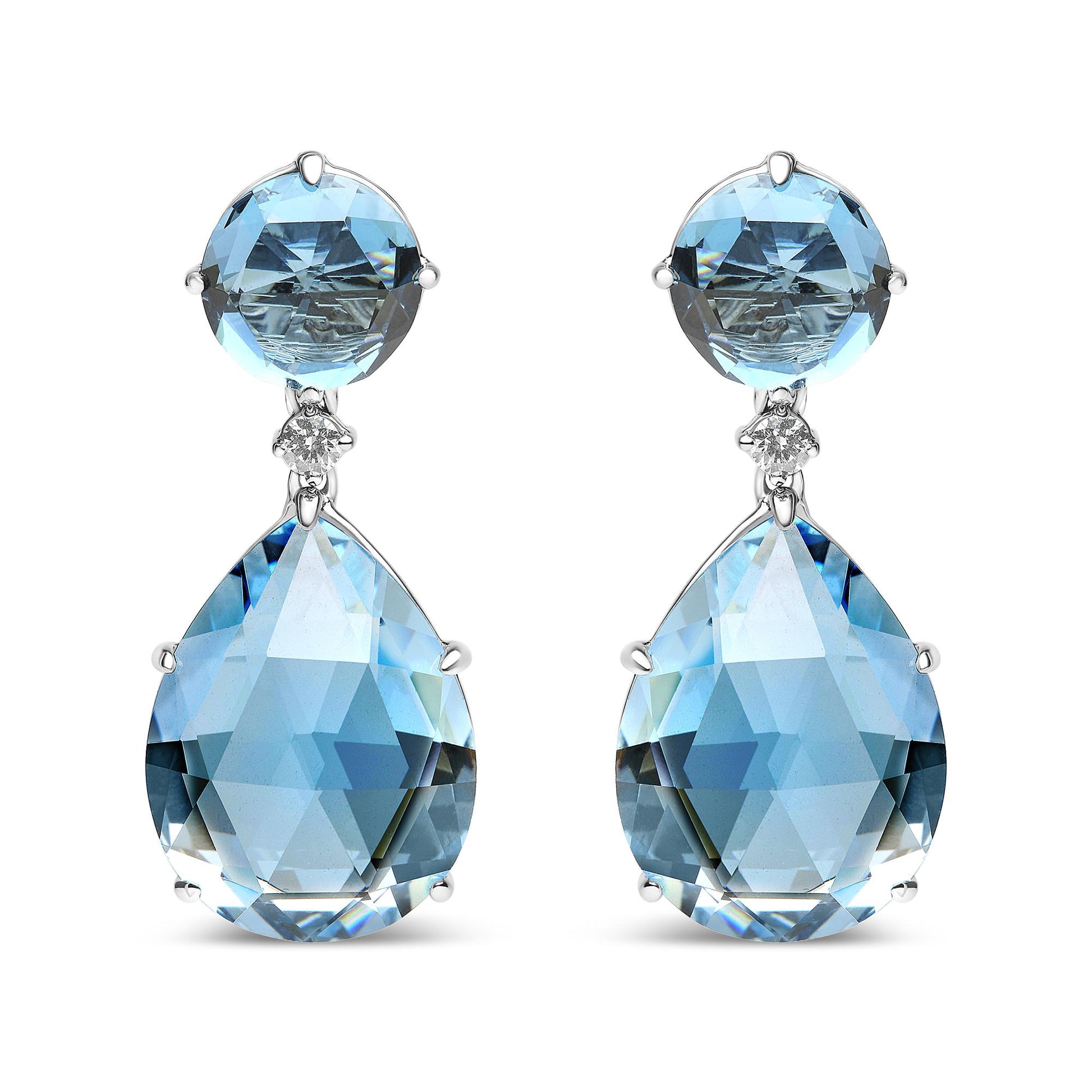 Front view of white metal earrings with a round blue gemstone at the top, a small white gemstone below it, and a large pear-shaped blue gemstone hanging at the bottom.