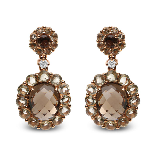 Front view of a pair of rose-colored metal drop earrings featuring oval smoky quartz center stones surrounded by smaller round smoky quartz gemstones, topped with a round cluster of smoky quartz stones and a single white gemstone in between.