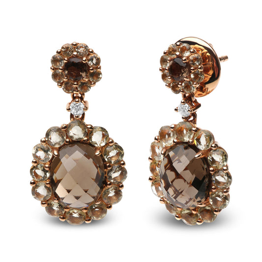 Front-facing shot of rose metal drop earrings featuring oval and round smoky gemstones surrounded by smaller round smoky and lemon-colored gemstones, each earring accented with a small white gemstone.