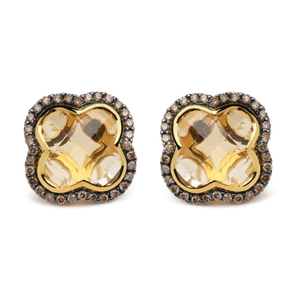 Front-facing close-up of yellow and black earrings with large yellow gemstones in the center surrounded by a border of small brown round gemstones set in prongs.