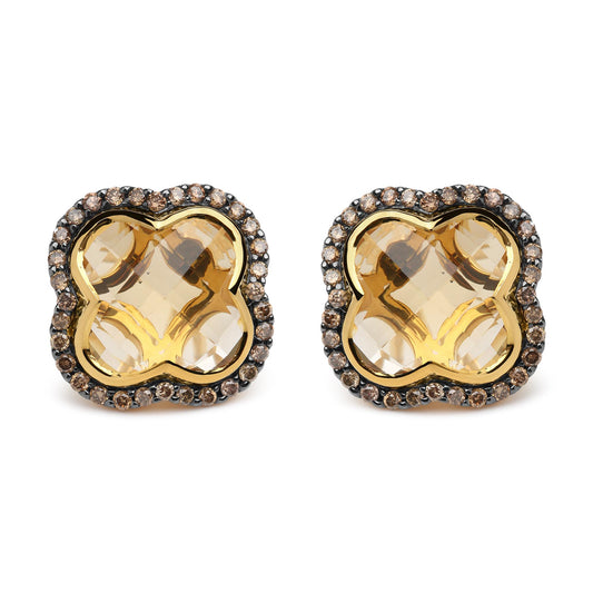 Front-facing close-up of yellow and black earrings with large yellow gemstones in the center surrounded by a border of small brown round gemstones set in prongs.
