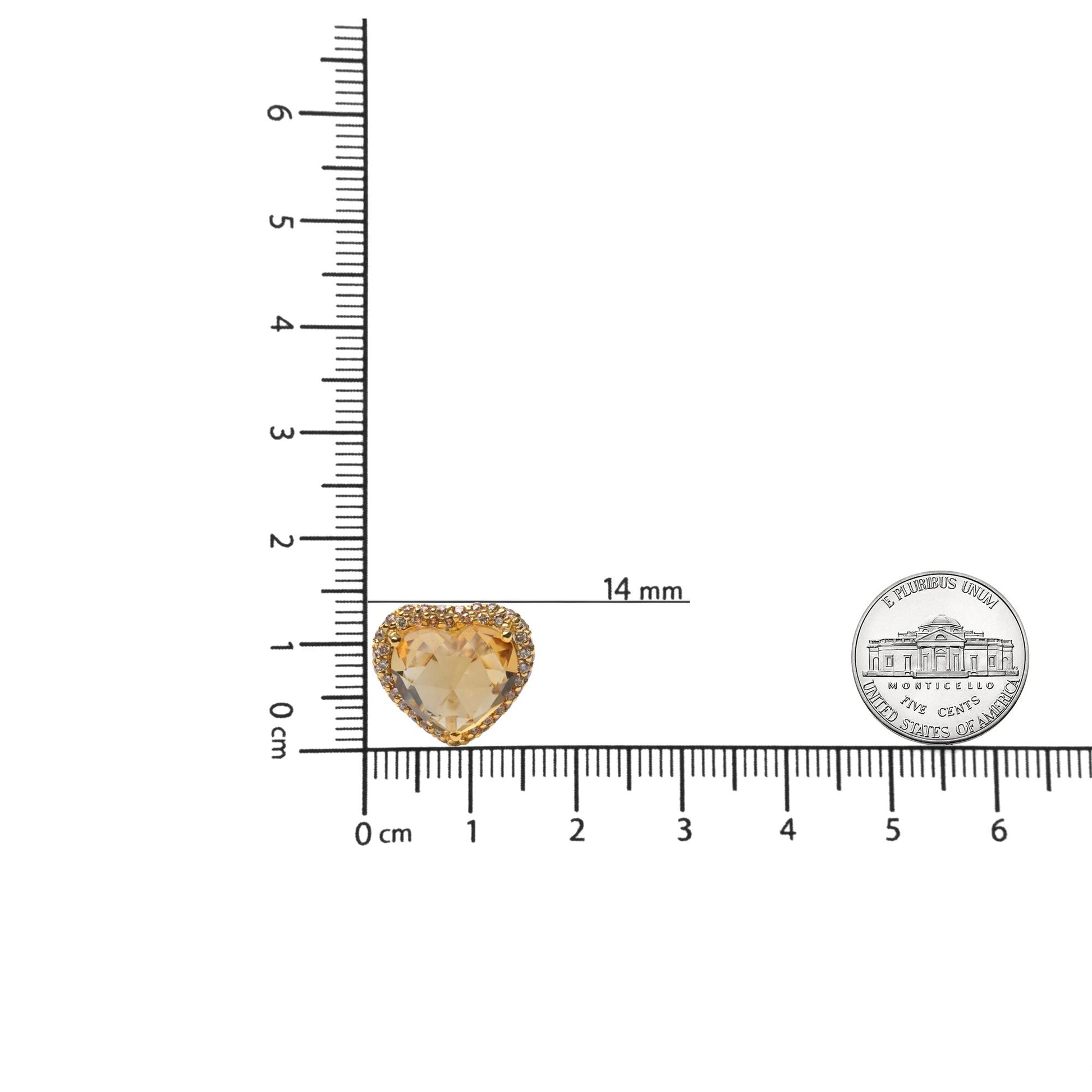 Yellow metal heart-shaped earrings with a central yellow heart-shaped gemstone surrounded by round brown gemstones, shown on a ruler for size reference from a top-down angle.