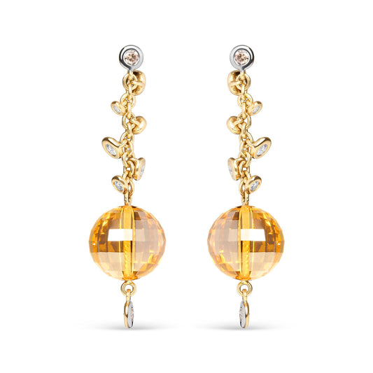 Front view of yellow metal drop earrings with round bezel-set brown and white gemstones along the chain and a large faceted yellow gemstone at the bottom.
