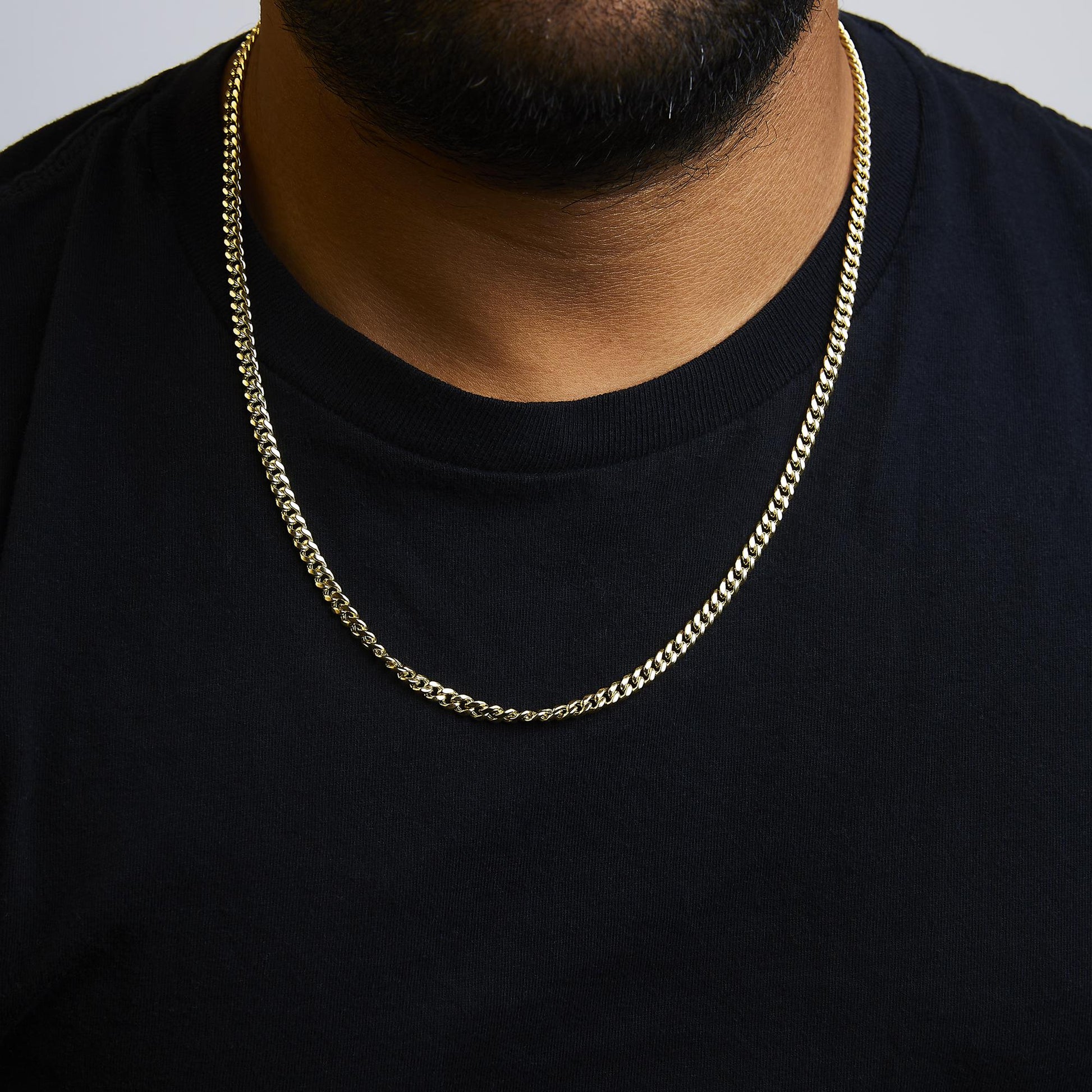 Yellow metal chain necklace shown worn on a model, front-facing close-up shot.