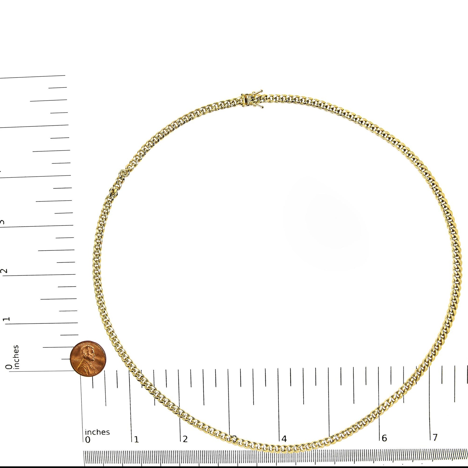 Top-down view of a yellow chain necklace displayed on a ruler and scale for size reference.