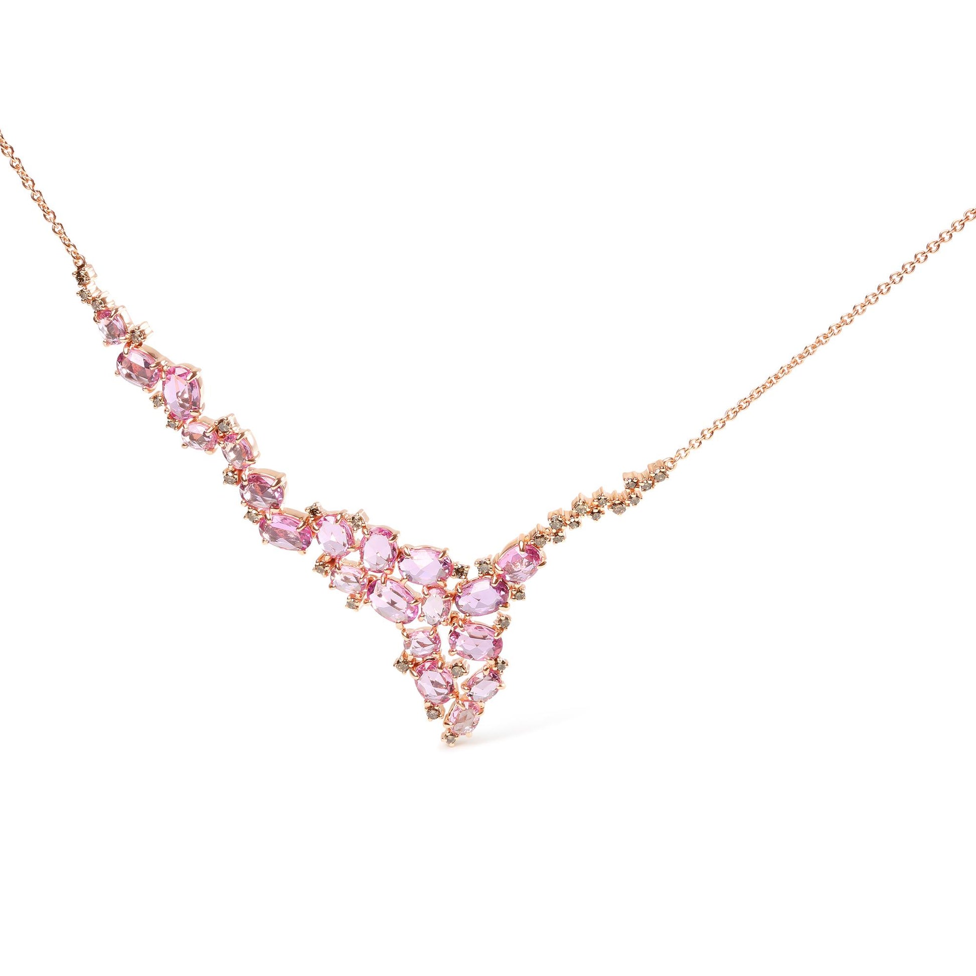Close-up, front-facing view of a rose metal necklace featuring a V-shaped cluster of pink oval gemstones surrounded by small round brown gemstones, all set in prongs.