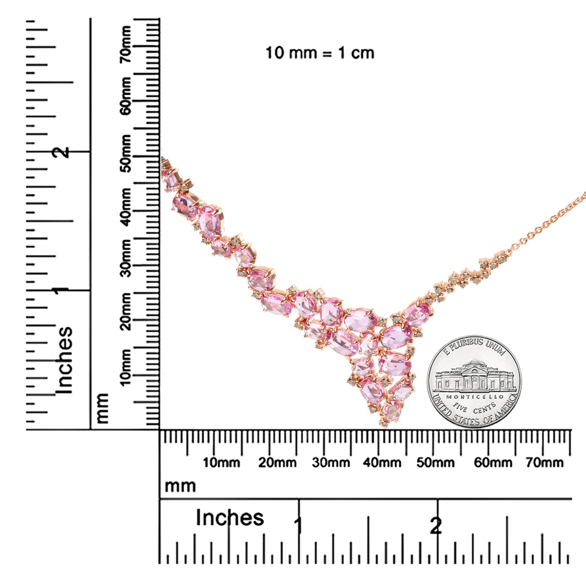 Rose metal necklace with pink oval gemstones and brown round gemstones in prong settings, displayed on a ruler and coin for size reference, angled diagonally.