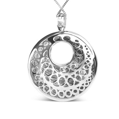 Close-up front view of a white metal circular necklace pendant with intricate cut-out patterns and a hollow center, suspended on a matching chain.