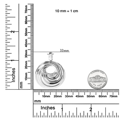 White metal circular swirl design pendant necklace shown from the front, placed on rulers and a coin for size reference.