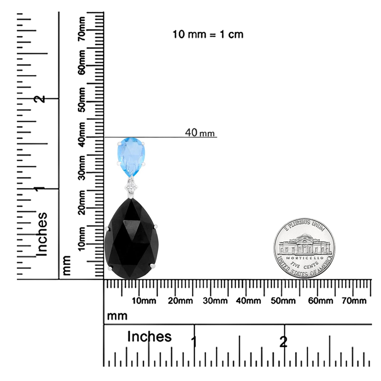 Close-up front view of a white necklace pendant with a round white gemstone between a pear-shaped blue gemstone above and a pear-shaped black gemstone below, displayed on a ruler and scale for size reference.