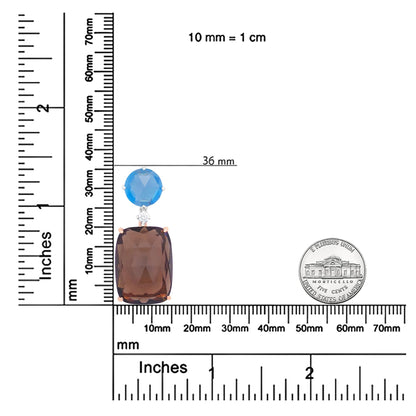 Necklace pendant with a large smoky cushion-shaped gemstone, a small white round gemstone, and a blue round gemstone, displayed on a ruler and alongside a coin for size reference, top-down angle.