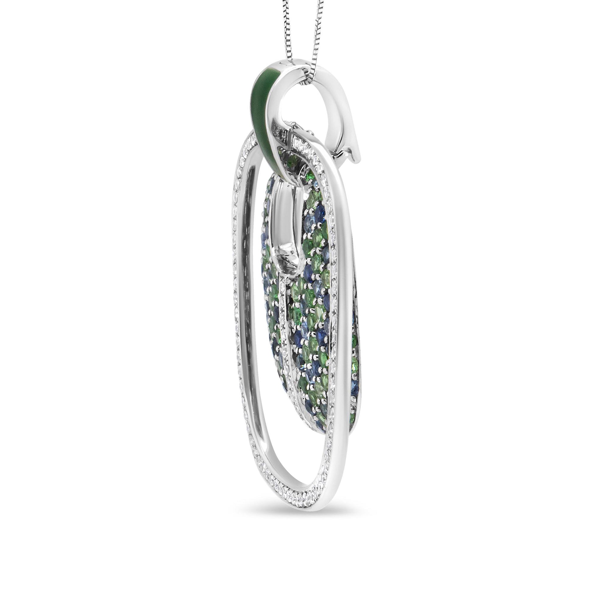 Side angle view of a white metal necklace pendant with an elongated oval shape, featuring prong-set white gemstones along the edges and inner design with alternating green and blue gemstones.