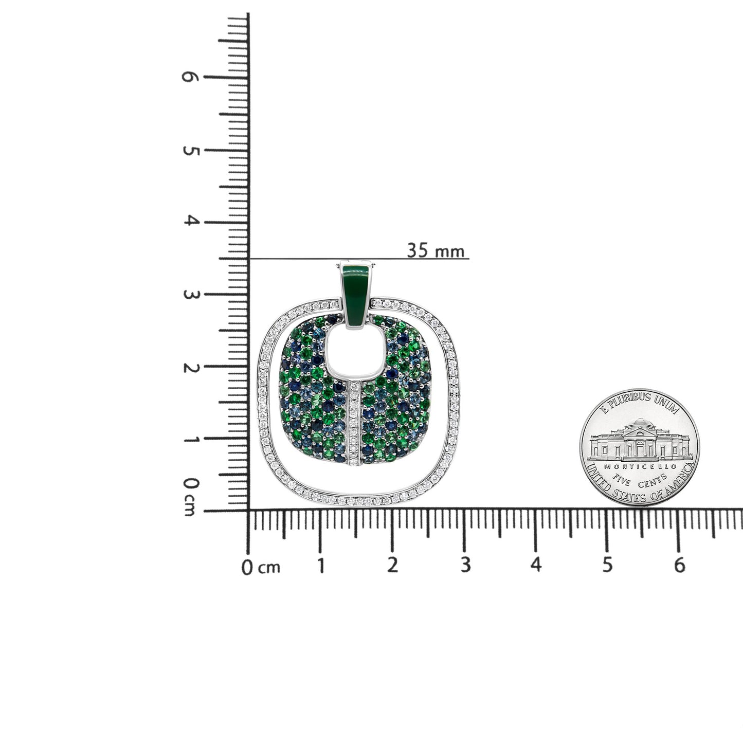 Top-down view of a white metal necklace pendant with an outer border of white round gemstones in prong settings, an inner area filled with blue and green gemstones, shown on a ruler with a coin for size reference.