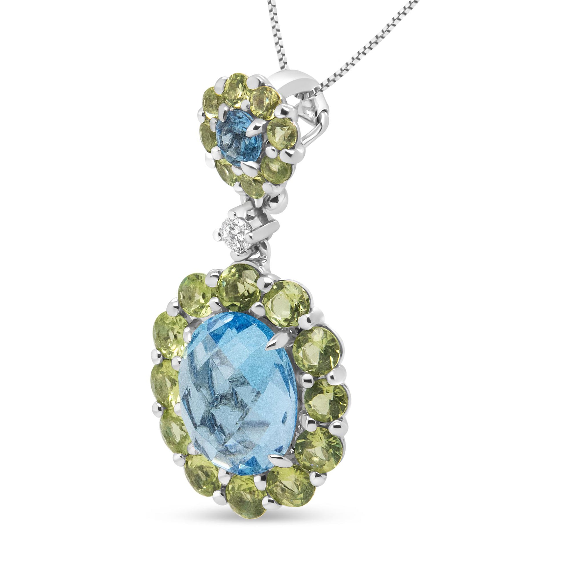 Close-up front angle of a white metal necklace pendant featuring an oval blue gemstone surrounded by round green gemstones, an additional round blue gemstone above, and a small round white gemstone in between.