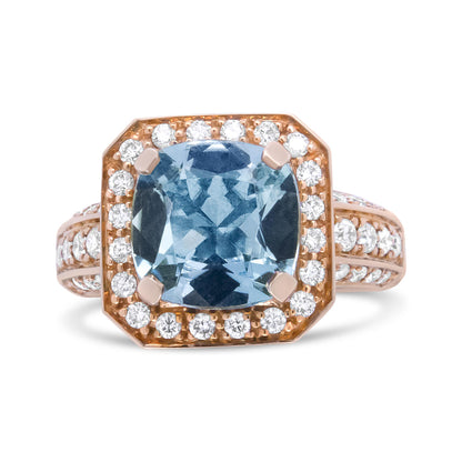Front-facing view of a yellow metal ring with a cushion-shaped blue gemstone in the center, surrounded by round white gemstones in prong settings.