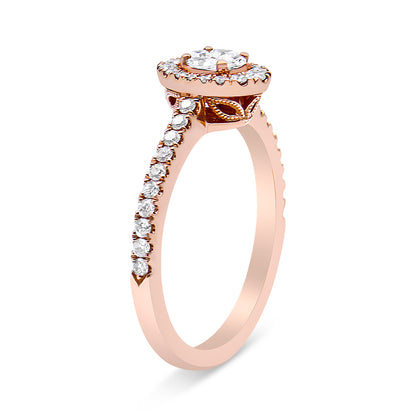 Side angle view of a rose-colored ring featuring a central princess-shaped white gemstone in a channel setting, surrounded by multiple round and marquise-shaped white gemstones in prong settings along the band and around the center.