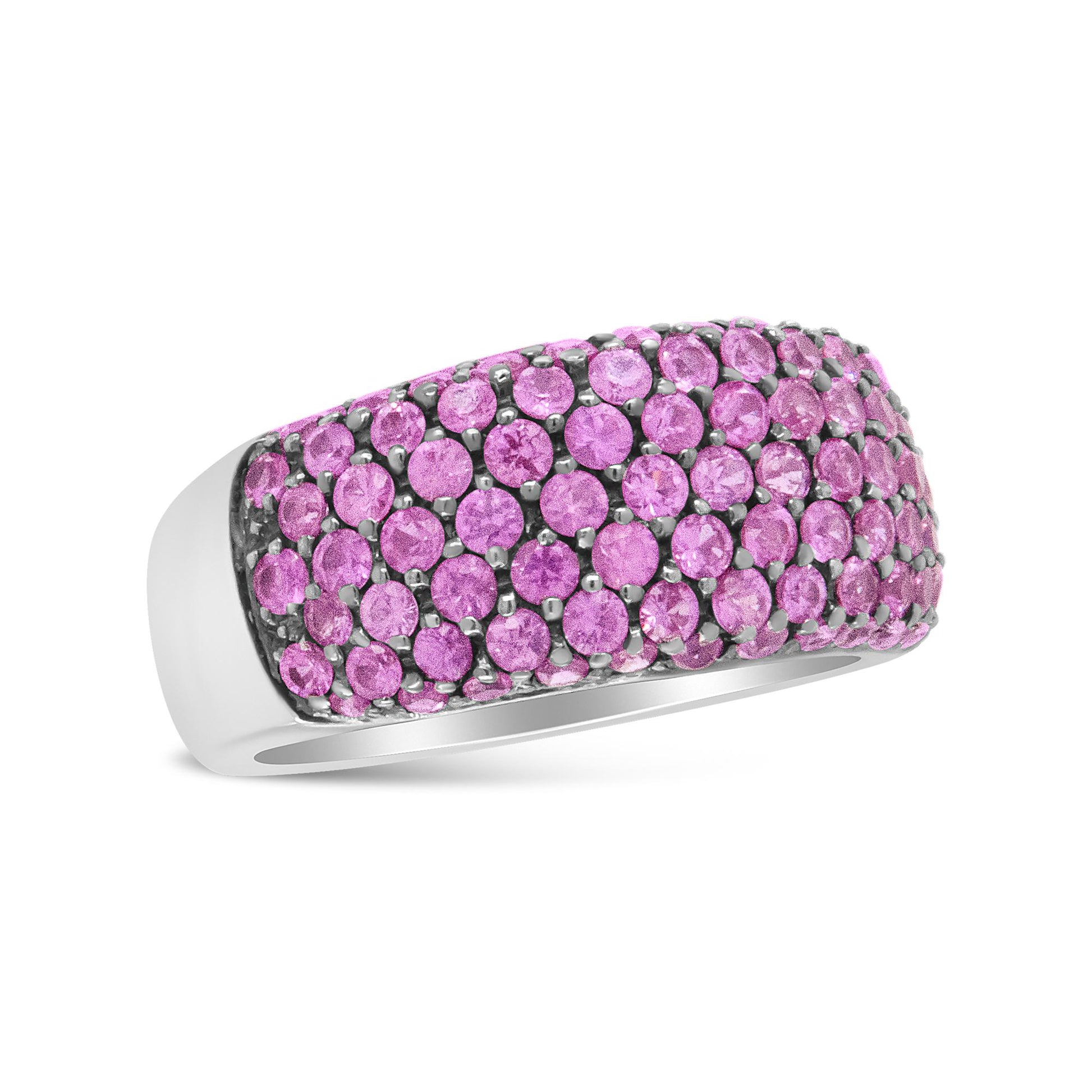 Close-up side angle of a white metal ring featuring multiple round pink gemstones in prong settings covering the top band.