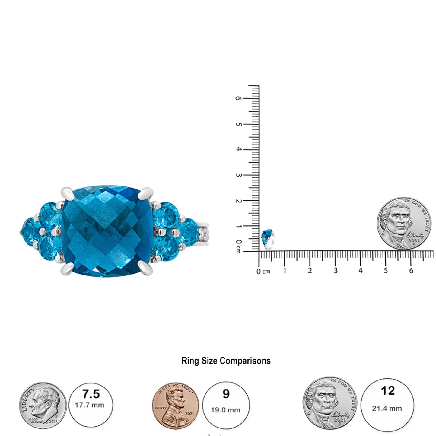 White metal ring with a large blue cushion-cut gemstone flanked by smaller blue round gemstones, shown from the front next to a ruler and coins for size reference.