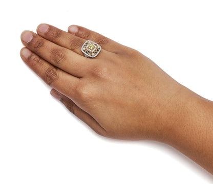 Ring with yellow, white, and rose metal featuring a square setting with yellow and white gemstones, worn on a model's hand, shown from above at an angle.