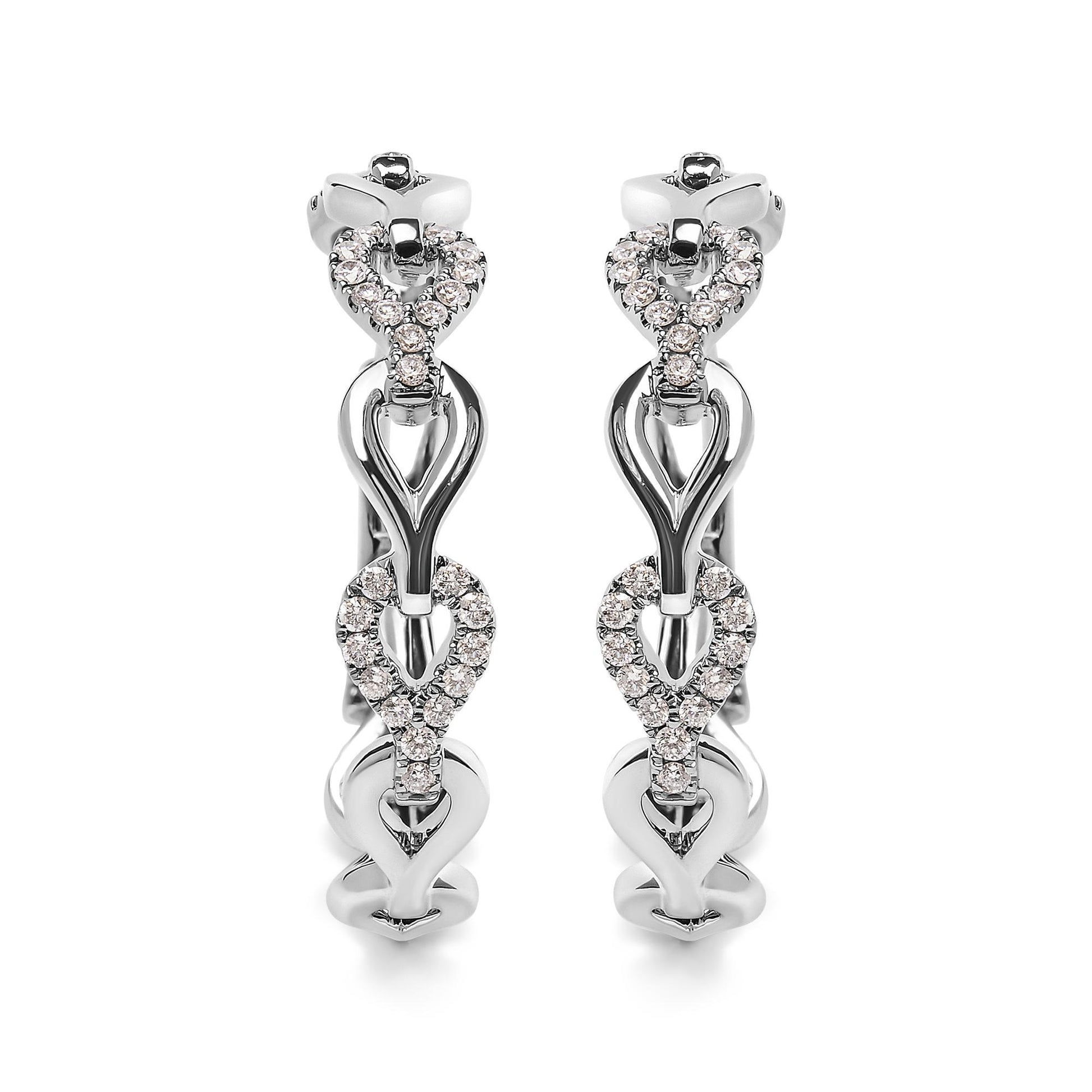 Front angle view of white metal hoop earrings with alternating plain and white gemstone-studded heart-shaped links.