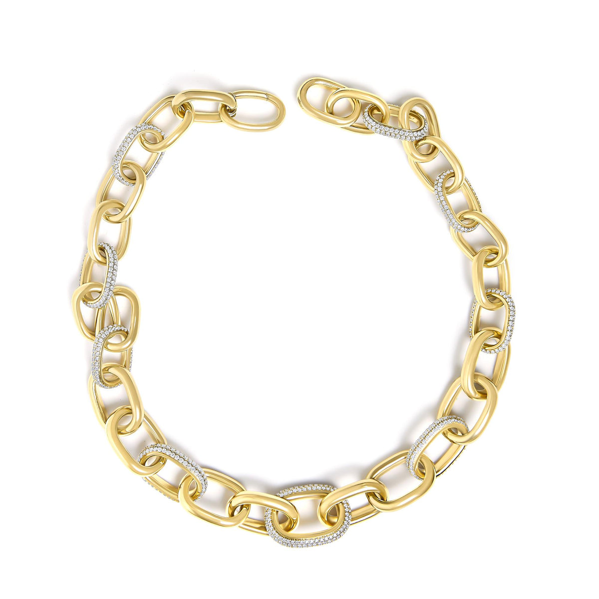 Close-up top view of a yellow metal chain necklace with alternating links, some set with white gemstones in pave setting.