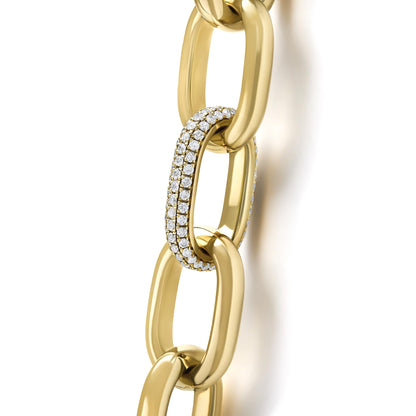 Close-up front angle of a yellow metal necklace with large chain links, one link is pavé-set with small white gemstones.
