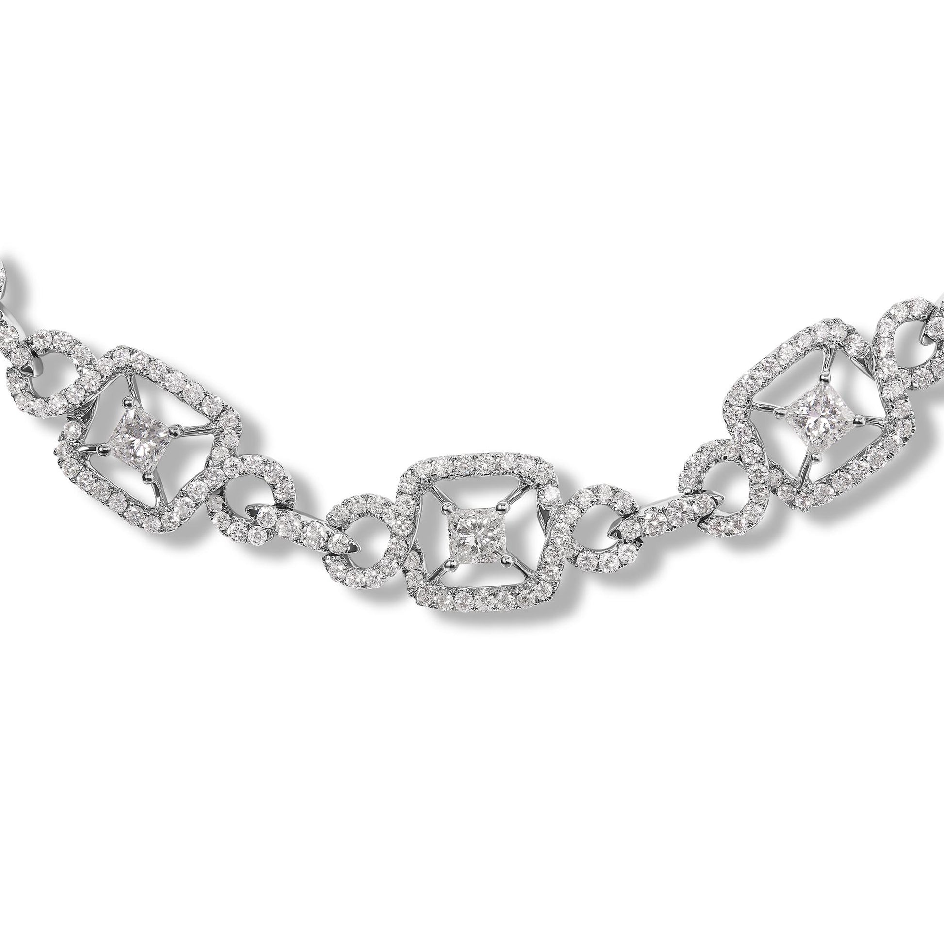 Close-up front angle of a white metal necklace featuring alternating princess-shaped and round-shaped white gemstones in prong settings, connected by round gemstone-encrusted links.