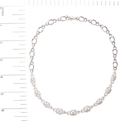 Top-down view of a white metal necklace with alternating geometric links, some adorned with prong-set white princess shape and round gemstones, displayed on a ruler for size reference.