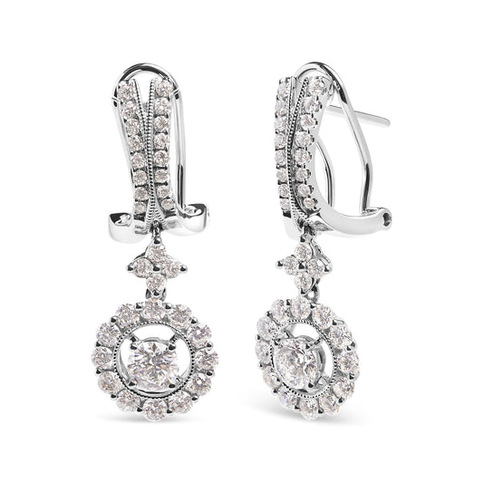 Front angle view of white metal drop earrings with clusters of round white gemstones in prong settings, featuring two larger central gemstones surrounded by smaller gemstones.