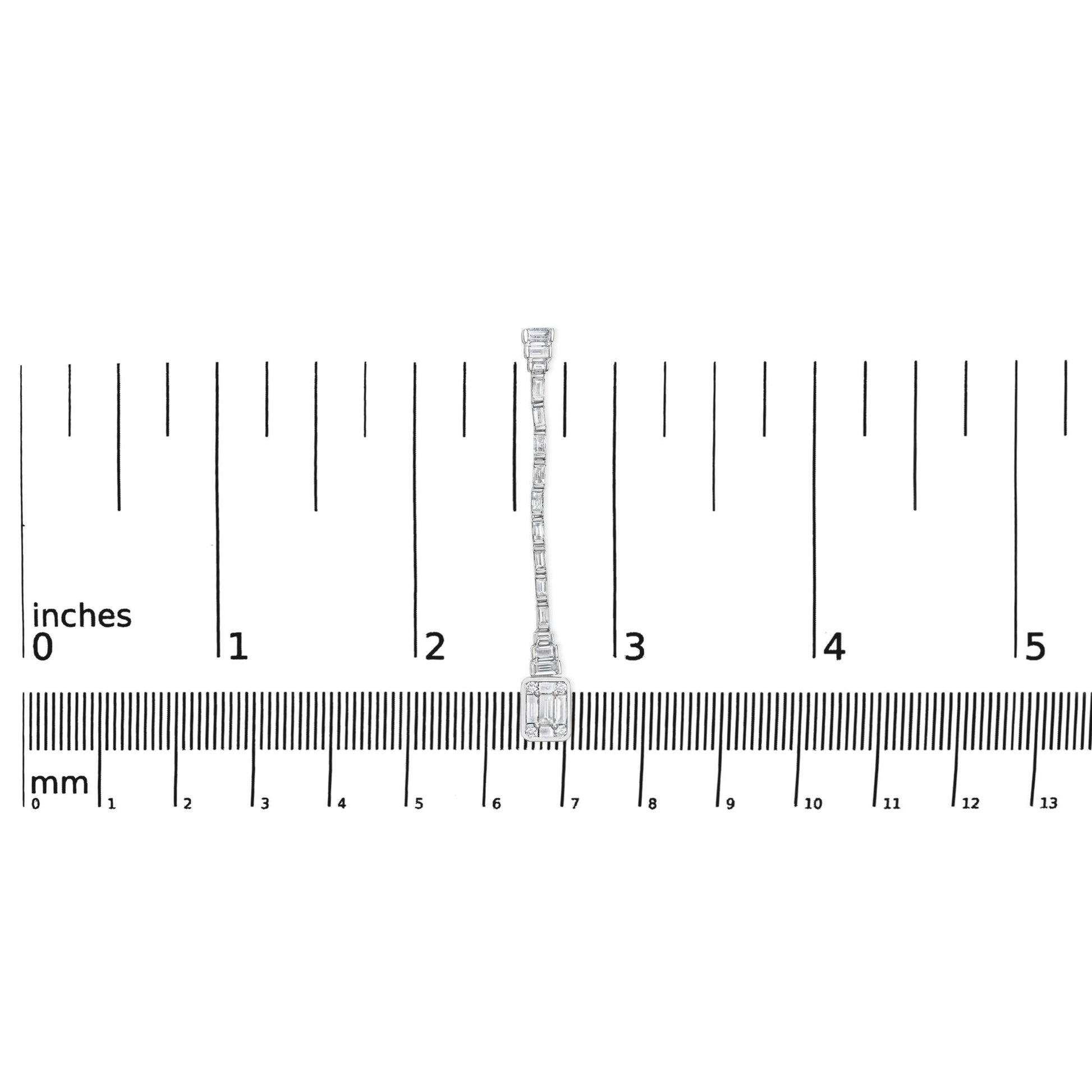 Single white metal earring with round and baguette white gemstones in bezel and channel settings, shown from front on a ruler for size reference.