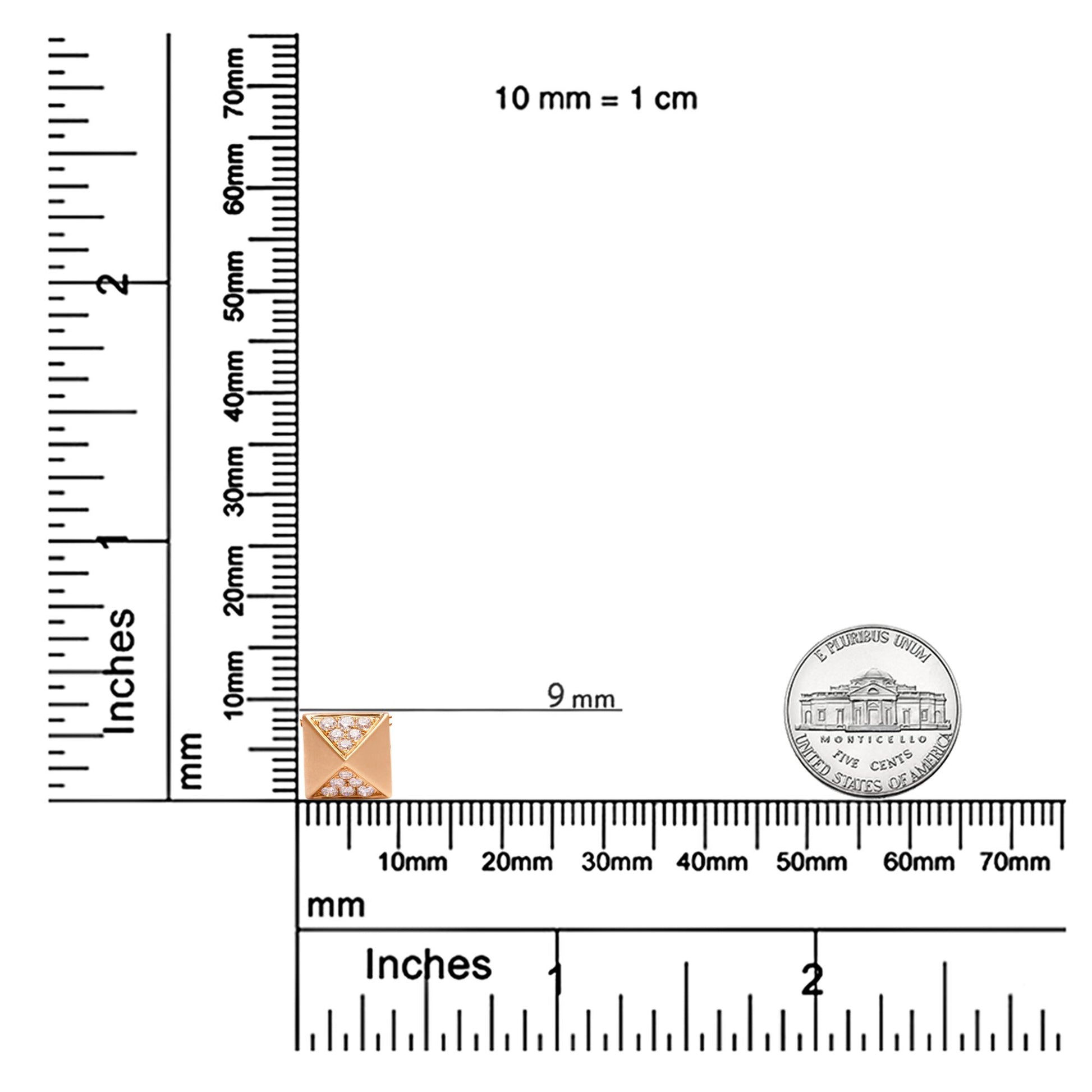 Yellow necklace pendant with a pyramid shape featuring white round gemstones in pave setting, shown on a ruler for size reference, top-down angle.