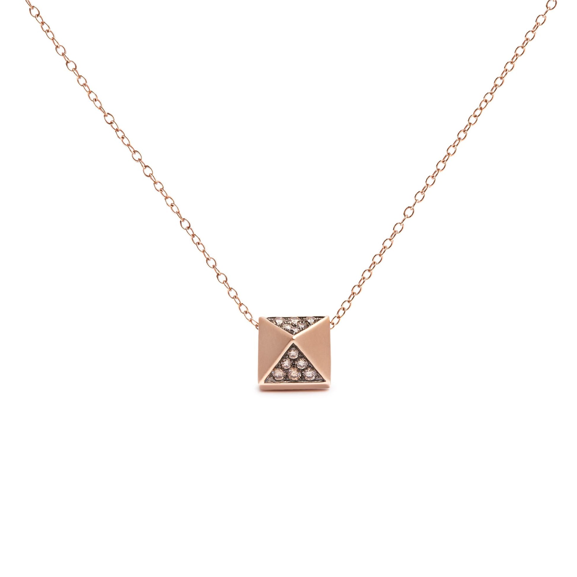 Front-facing shot of a rose-colored metal necklace with a square pendant featuring triangular sections, two of which are inset with round brown gemstones in a pave setting.