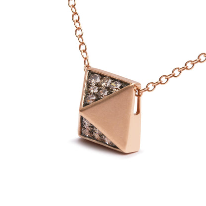 Close-up angled view of a rose-colored necklace with a geometric pendant, featuring a triangular pave setting with round brown gemstones on half of the pendant.