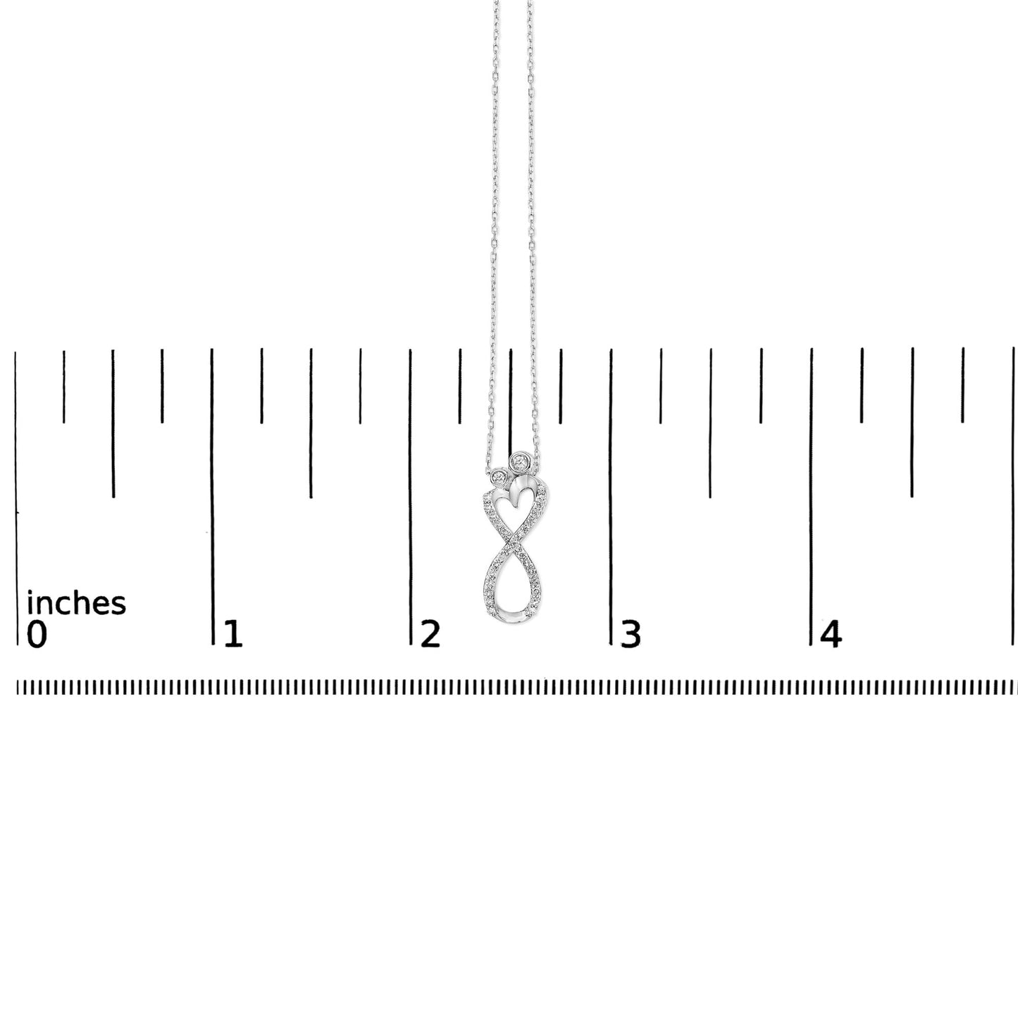 White metal necklace with an infinity and heart-shaped pendant featuring round white gemstones in bezel and shared prong settings, shown on a scale from a front angle.