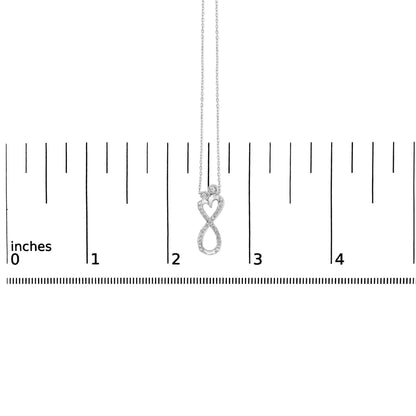White metal necklace with an infinity and heart-shaped pendant featuring round white gemstones in bezel and shared prong settings, shown on a scale from a front angle.
