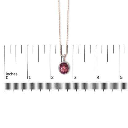 Rose-colored necklace with a pink oval gemstone pendant surrounded by small white gemstones, shown on a scale, front-facing angle.