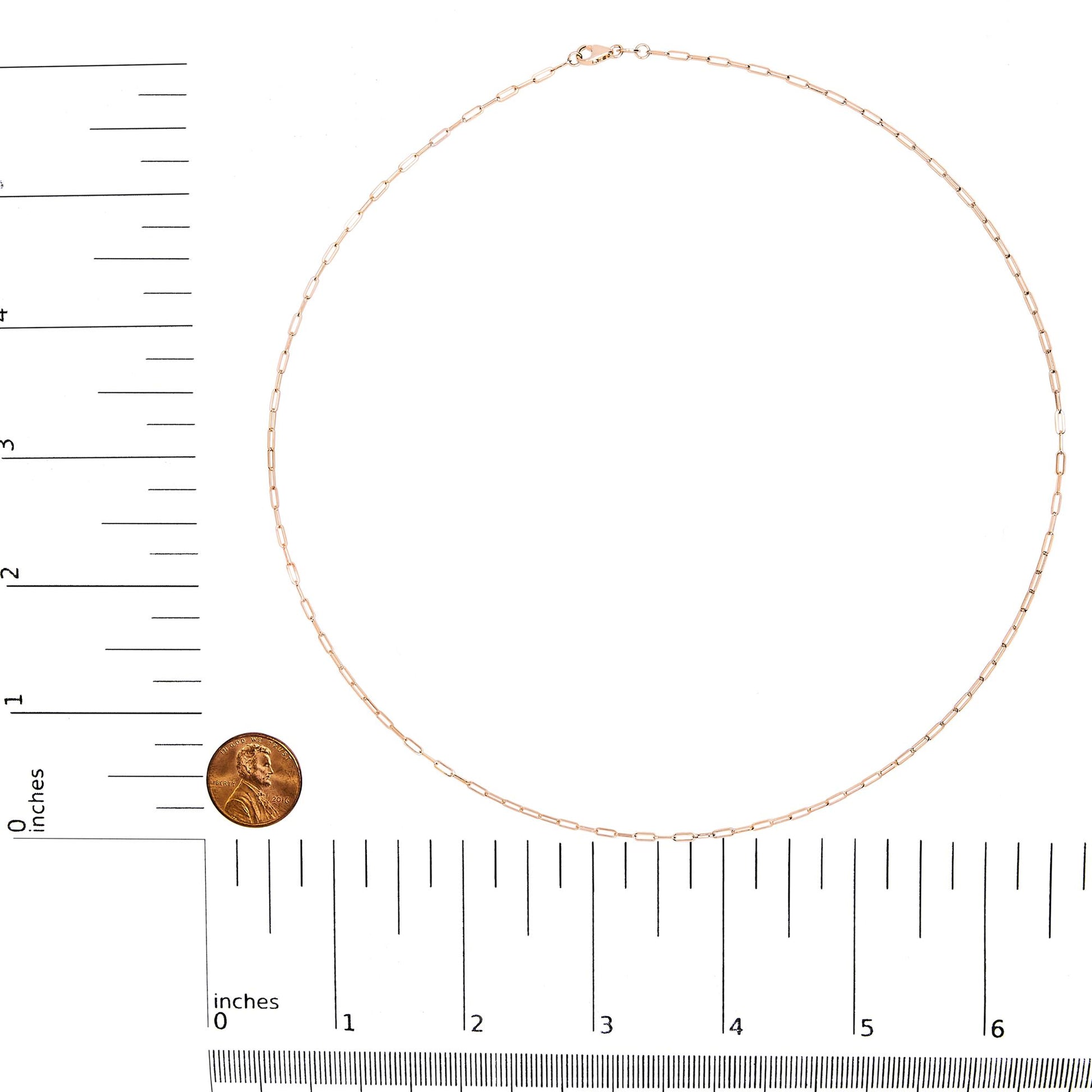 Rose-colored chain with elongated links displayed flat on a white background, shot from above with rulers and a coin for size reference.