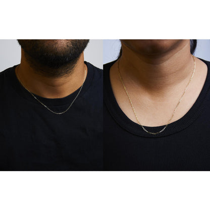 Side-by-side close-up images of a yellow metal chain necklace on two models wearing black tops, shown from the neck to upper chest at a frontal angle.