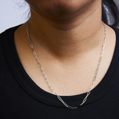 White chain necklace with elongated rectangular links, shown worn on a model, front close-up view.
