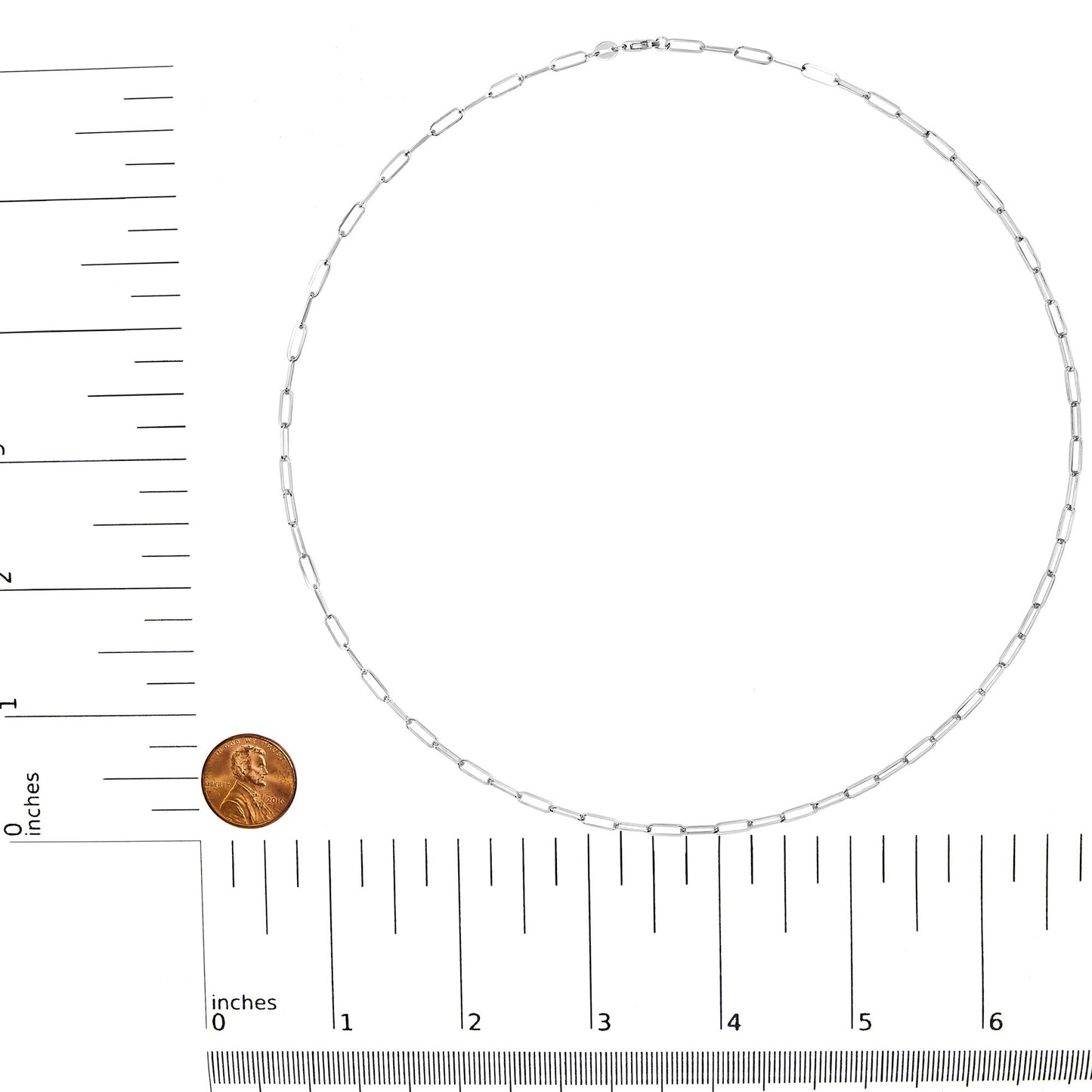 White metal chain with elongated rectangular links, laid flat in a circular shape on a white background with a ruler and a coin for size reference, shot from above.