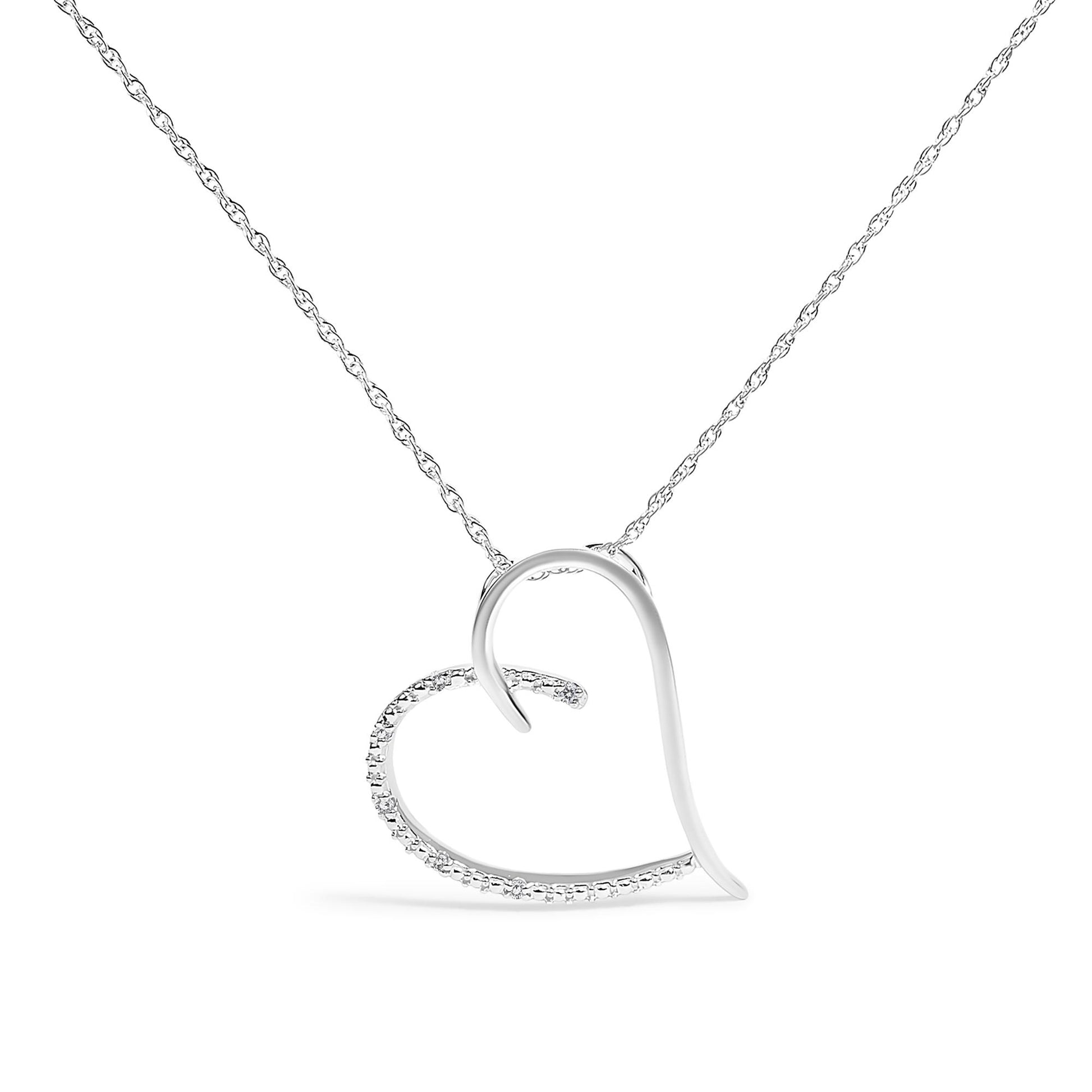 Front view of white metal heart-shaped necklace with one side smooth and the other side adorned with small white gemstones in prong settings.