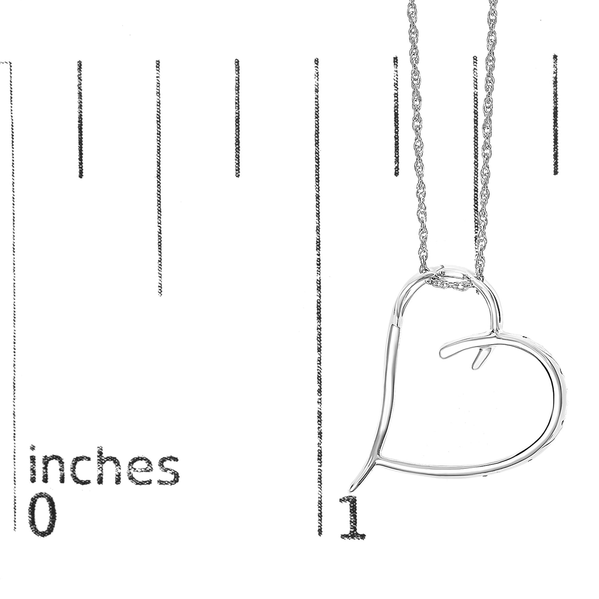 Close-up front view of a white metal heart-shaped necklace pendant with six round white gemstones in prong settings, displayed on a ruler for size reference.