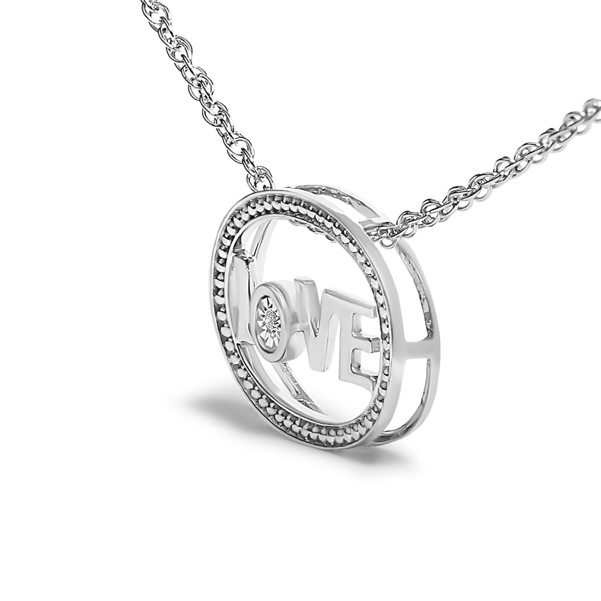 White metal necklace with circular pendant featuring the word 'LOVE' inside and a single round white gemstone in the letter 'O,' shown in a close-up angled view.